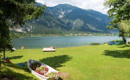 Liegewiese am See mit Boot und Bergblick