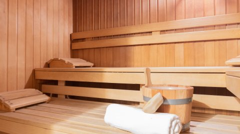 Sauna mit Eimer, Handtuch und hölzerner Liegefläche