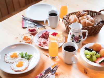 Rustikales Frühstück mit Eiern, Saft, Brot und Obst