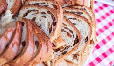 Rosinenstriezel auf Holzbrett mit kariertem Tischtuch