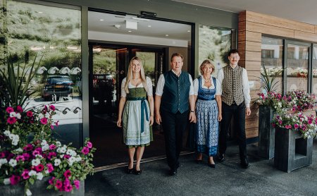 Familie in Tracht vor dem Hoteleingang