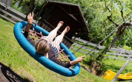 Woman relaxing on blue nest swing
