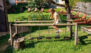 Girl climbing rope bridge with wooden steps