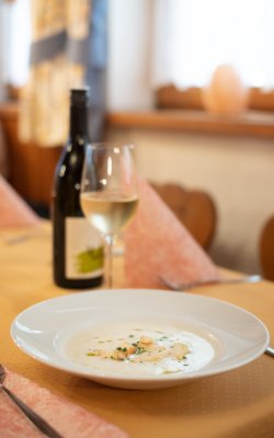 Cremesuppe mit Wein auf gedecktem Tisch serviert