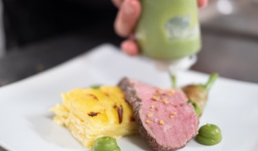 Zartes Rind mit Kartoffelgratin wird angerichtet