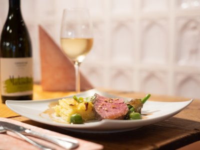 Feines Hauptgericht mit Weißwein auf Holztisch
