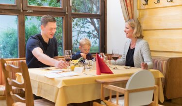 Familie beim Abendessen mit Kleinkind im gemütlichen Restaurant