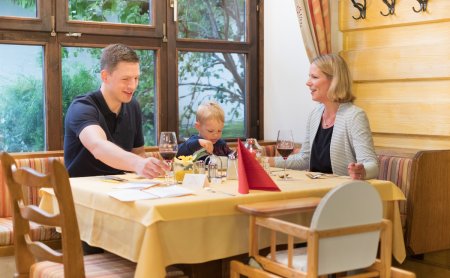 Familie beim Abendessen mit Kleinkind im gemütlichen Restaurant