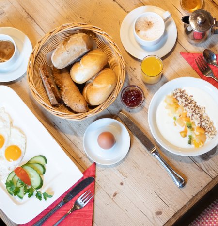 Frühstück mit Spiegelei, Gebäck und Joghurt