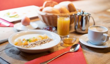 Reich gedeckter Frühstückstisch mit Brötchen