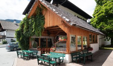 Überdachte Terrasse mit Rankpflanzen und Biergläsern