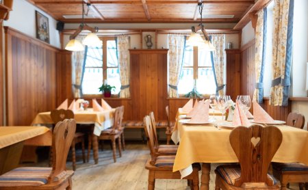 Holzgetäfelter Speiseraum mit liebevoll gedeckten Tischen