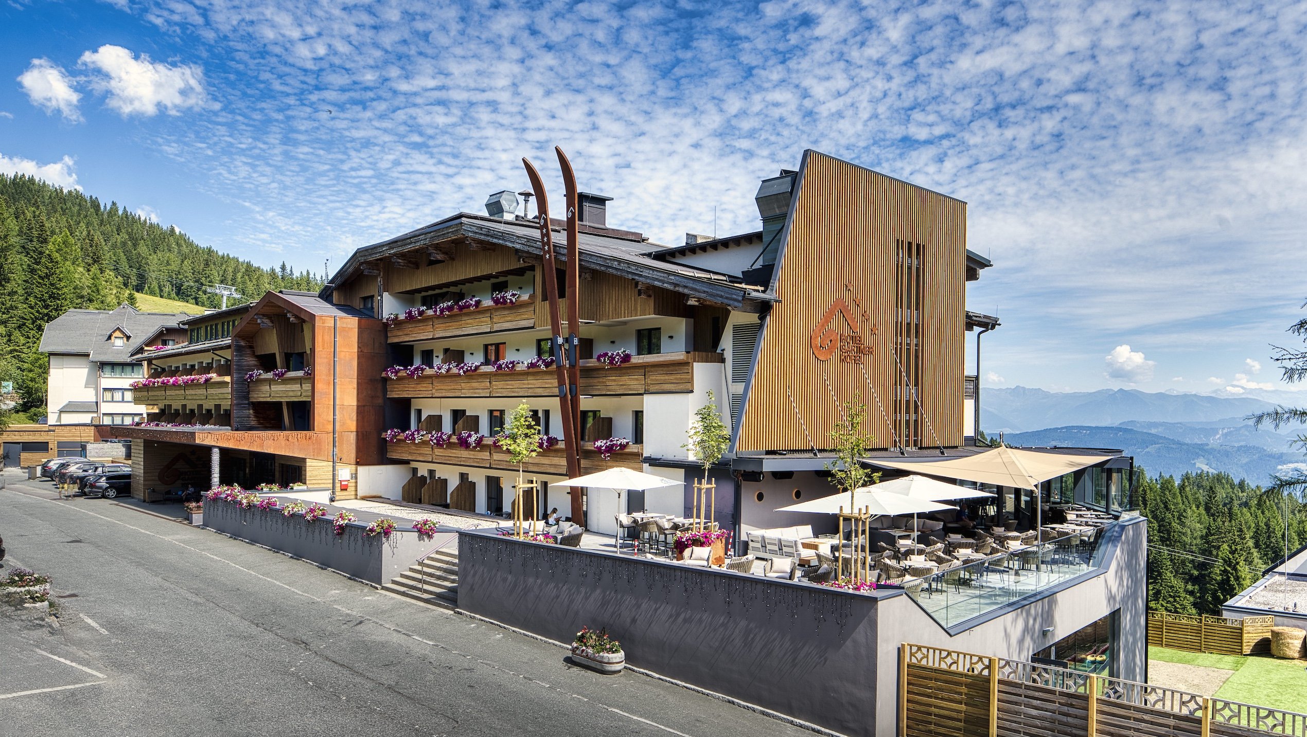 Moderne Hotelansicht mit Sonnenterrasse und Panoramablick vom Hotel Gartnerkofel