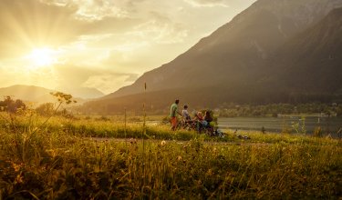 Familie genießt Sonnenuntergang am See