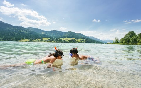 Zwei Kinder schnorcheln im klaren Wasser
