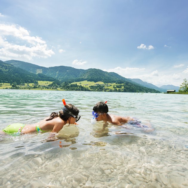 Zwei Kinder schnorcheln im klaren Wasser
