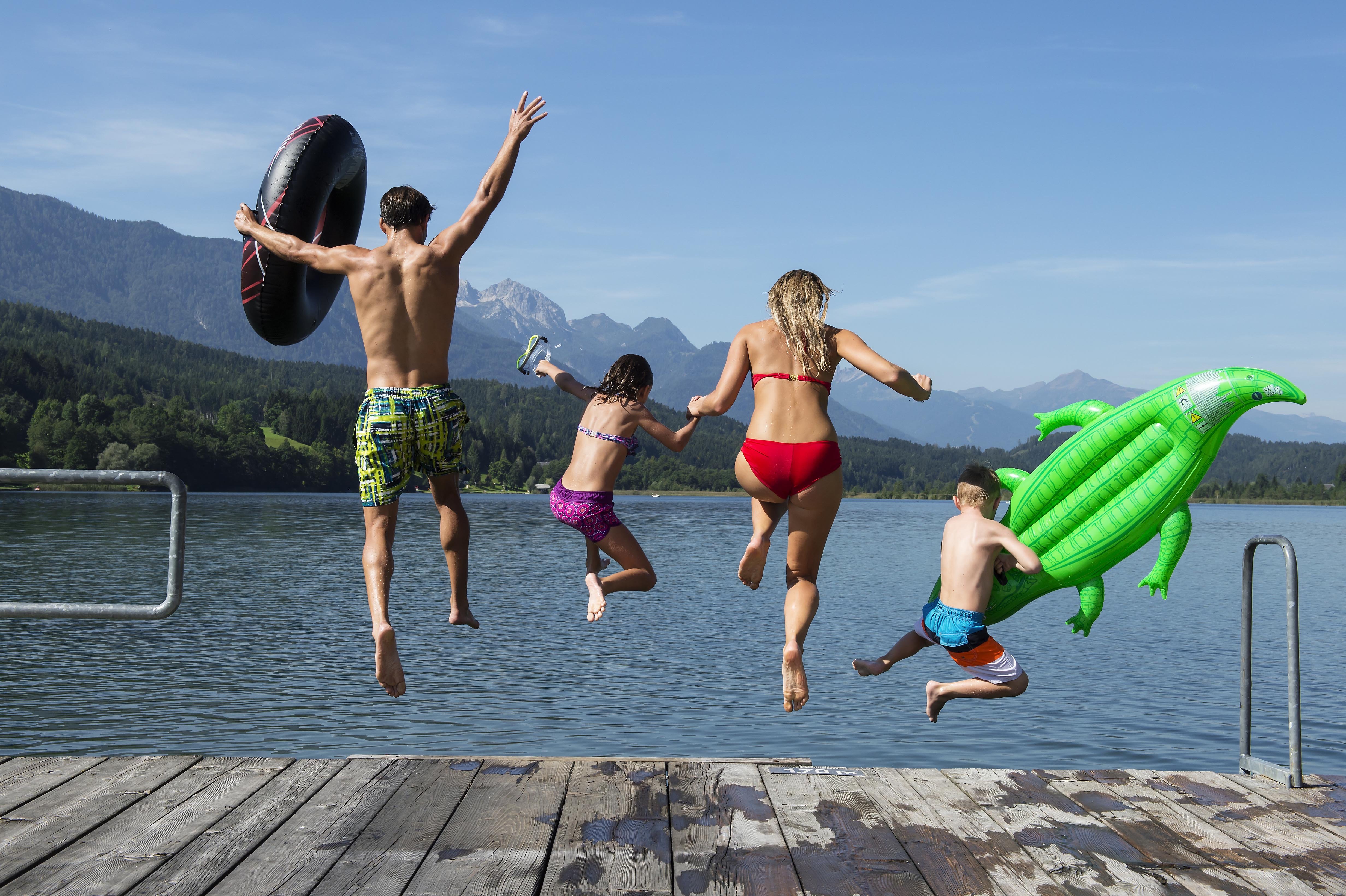 Familie springt gemeinsam vom Badesteg