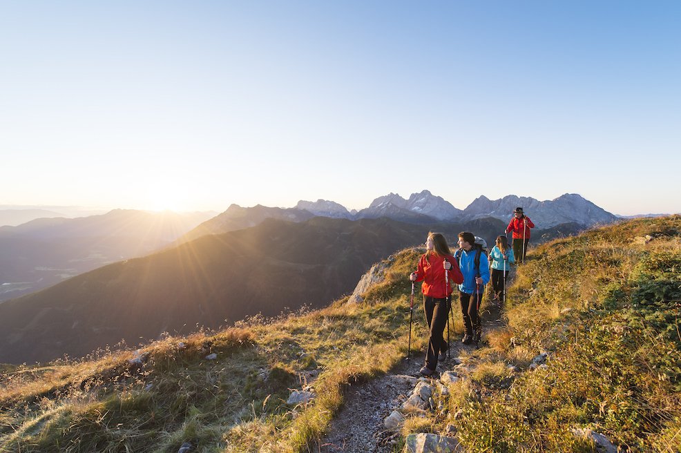 Gruppe wandert in Morgenlicht durch die Berge