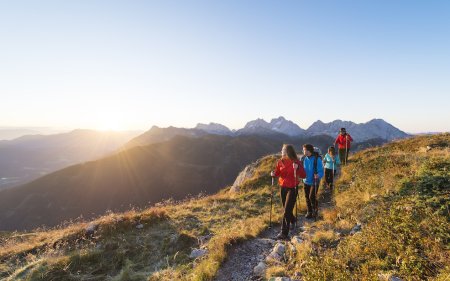 Gruppe wandert in Morgenlicht durch die Berge