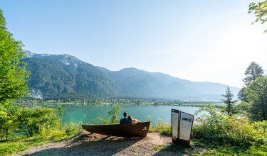 Paar entspannt auf Bank mit Seeblick