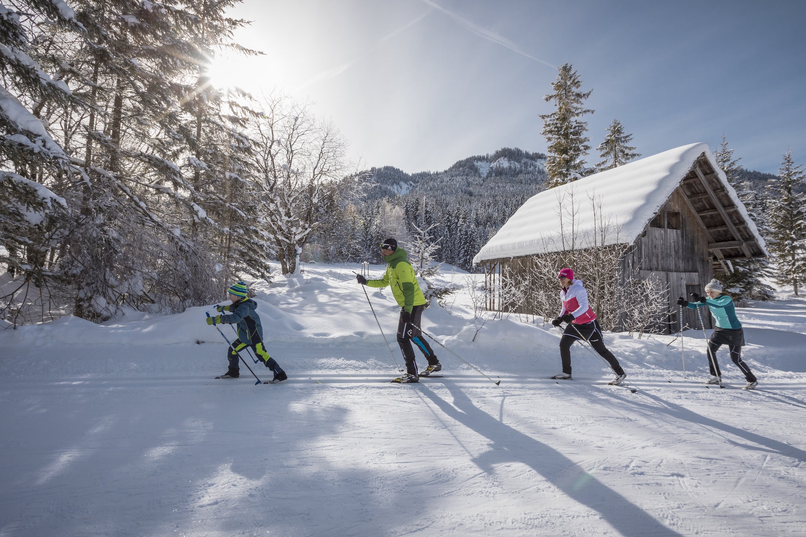 Familie beim Langlaufen durch Winterlandschaft