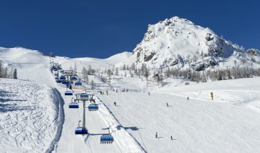 Skifahrer unter Sessellift bei blauem Himmel