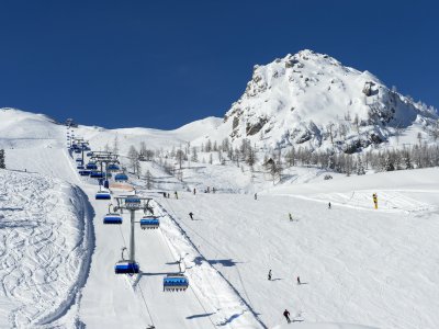 Skifahrer unter Sessellift bei blauem Himmel