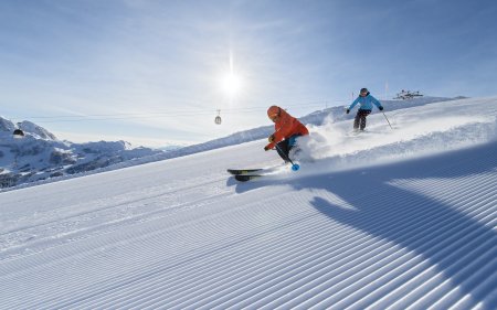 Skiers on freshly groomed slope