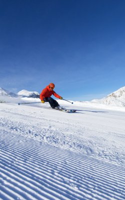 Schwungvolle Abfahrt bei strahlend blauem Himmel