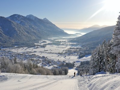Blick von der Piste auf verschneites Tal