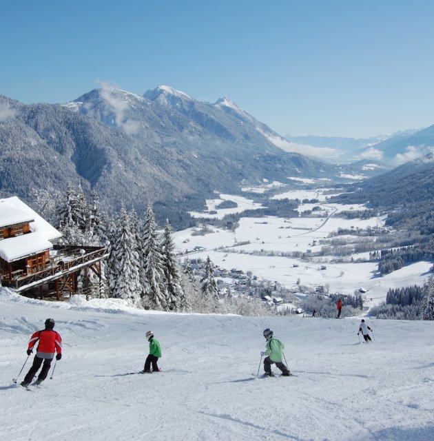 Skifahrer vor Hütte mit Talblick