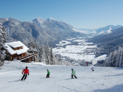 Skifahrer vor Hütte mit Talblick