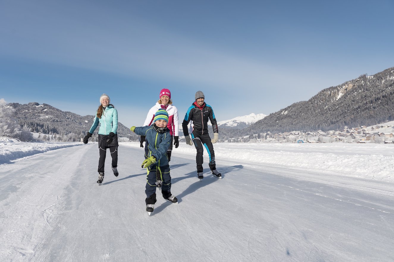 Family ice skating on frozen lake