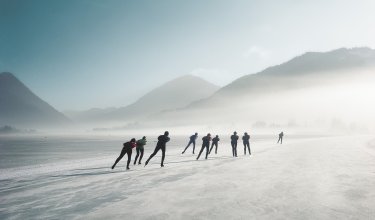 Eisläufer auf zugefrorenem See im Nebel