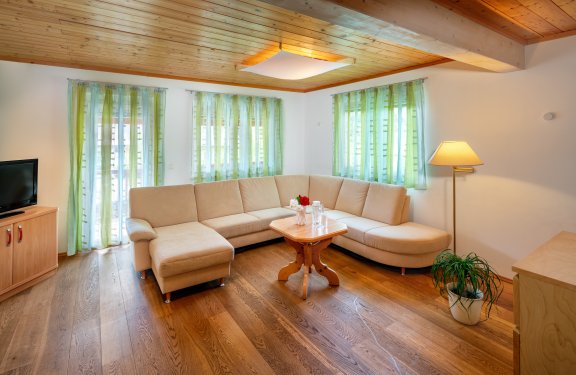 Gemütliches Wohnzimmer mit heller Eckcouch und Holzelementen