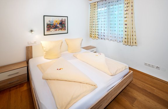 Helles Schlafzimmer mit Doppelbett und warmer Bettwäsche