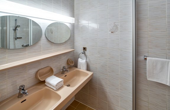 Bad mit zwei Waschbecken und Dusche in Beige