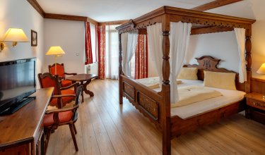 Gemütliches Zimmer mit Himmelbett und TV