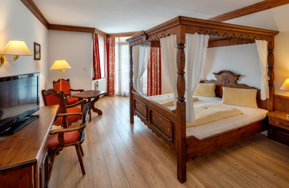 Gemütliches Zimmer mit Himmelbett und TV