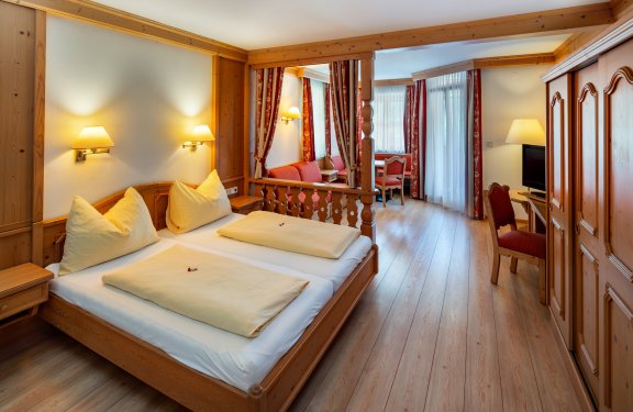 Gemütliches Zimmer mit roter Sitzecke und Balkon