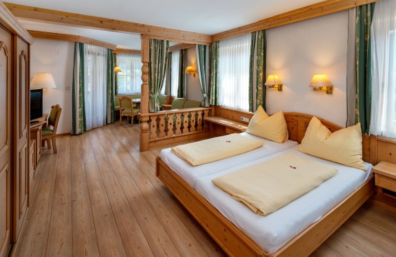 Gemütliches Zimmer mit Holzbett und Sitzbereich