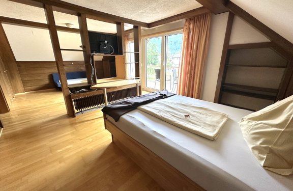 Gemütliches Zimmer mit offenem Wohnbereich und Balkon