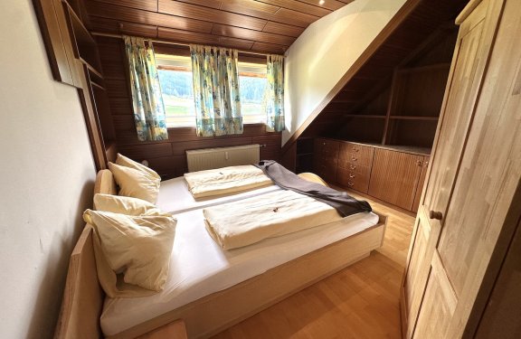 Schlafzimmer mit Dachschräge und Holzverkleidung